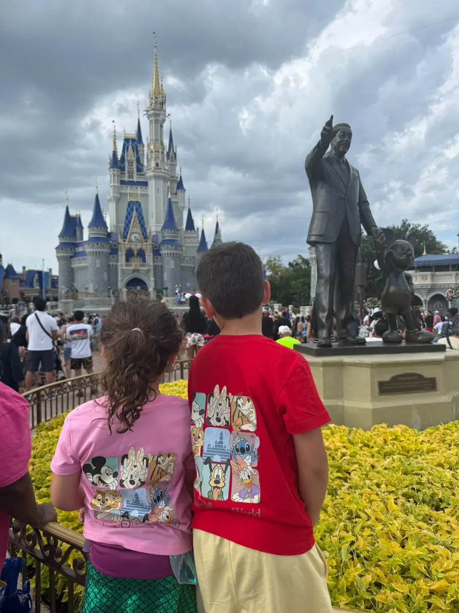 Niños frente al castillo de Cenicienta y la estatua de Walt y Mickey en Magic Kingdom